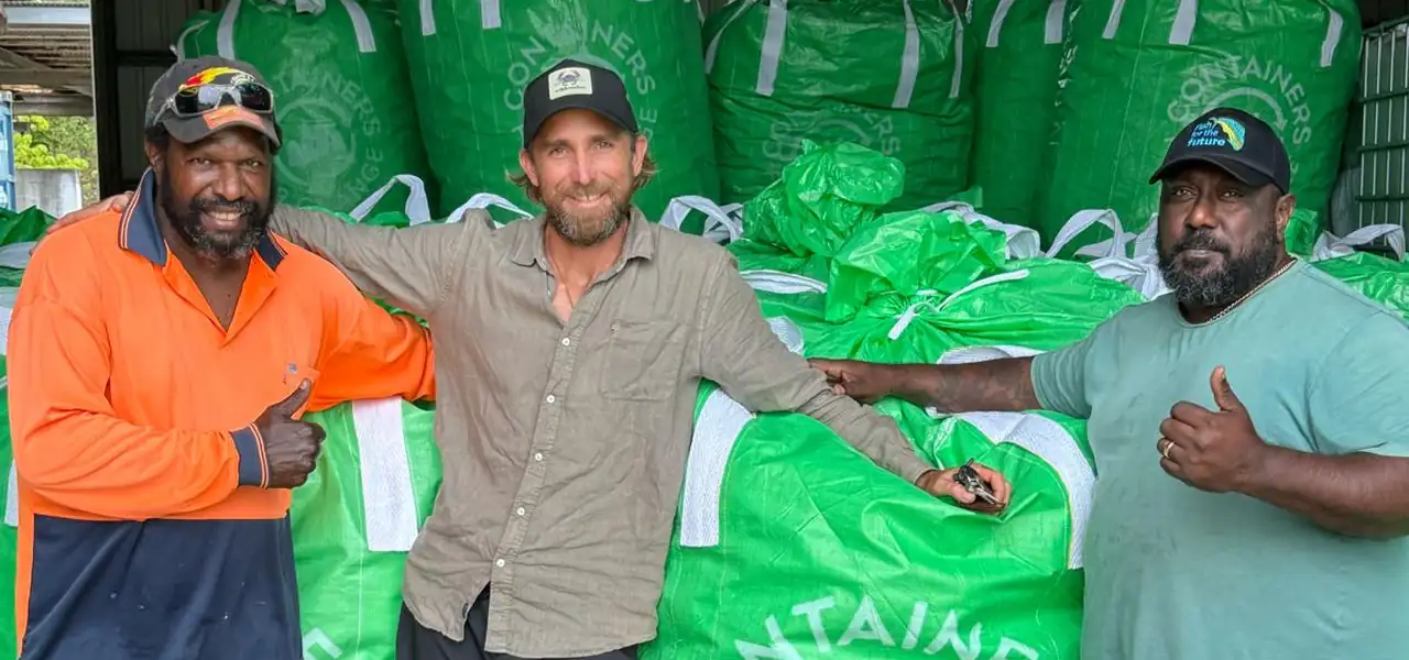 Crew and a visitor beside filled Containers for Change collection bags.