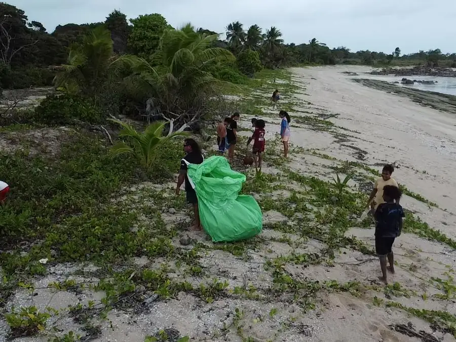 Community members collecting debris along the Badu Island shoreline.
